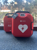 Defibrylator HeartSave AED z szafką i oznakowaniem